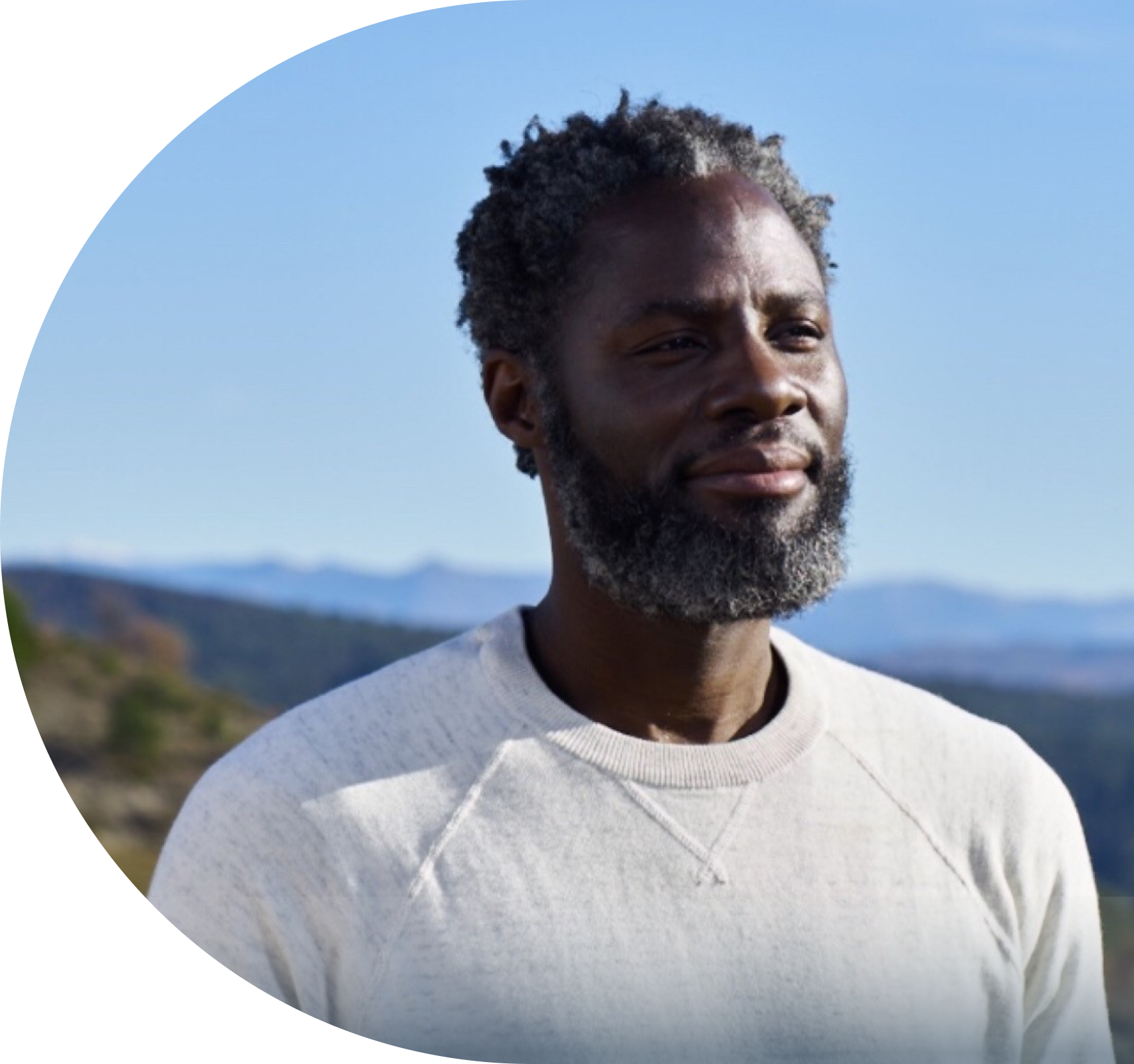 Man smiling and looking into the distance.
